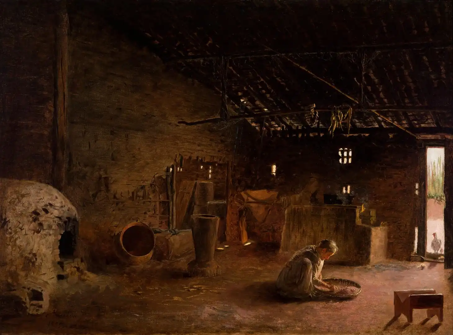 Dark interior of a rustic kitchen with a domed clay oven on the left and a woman sifting grain on the floor