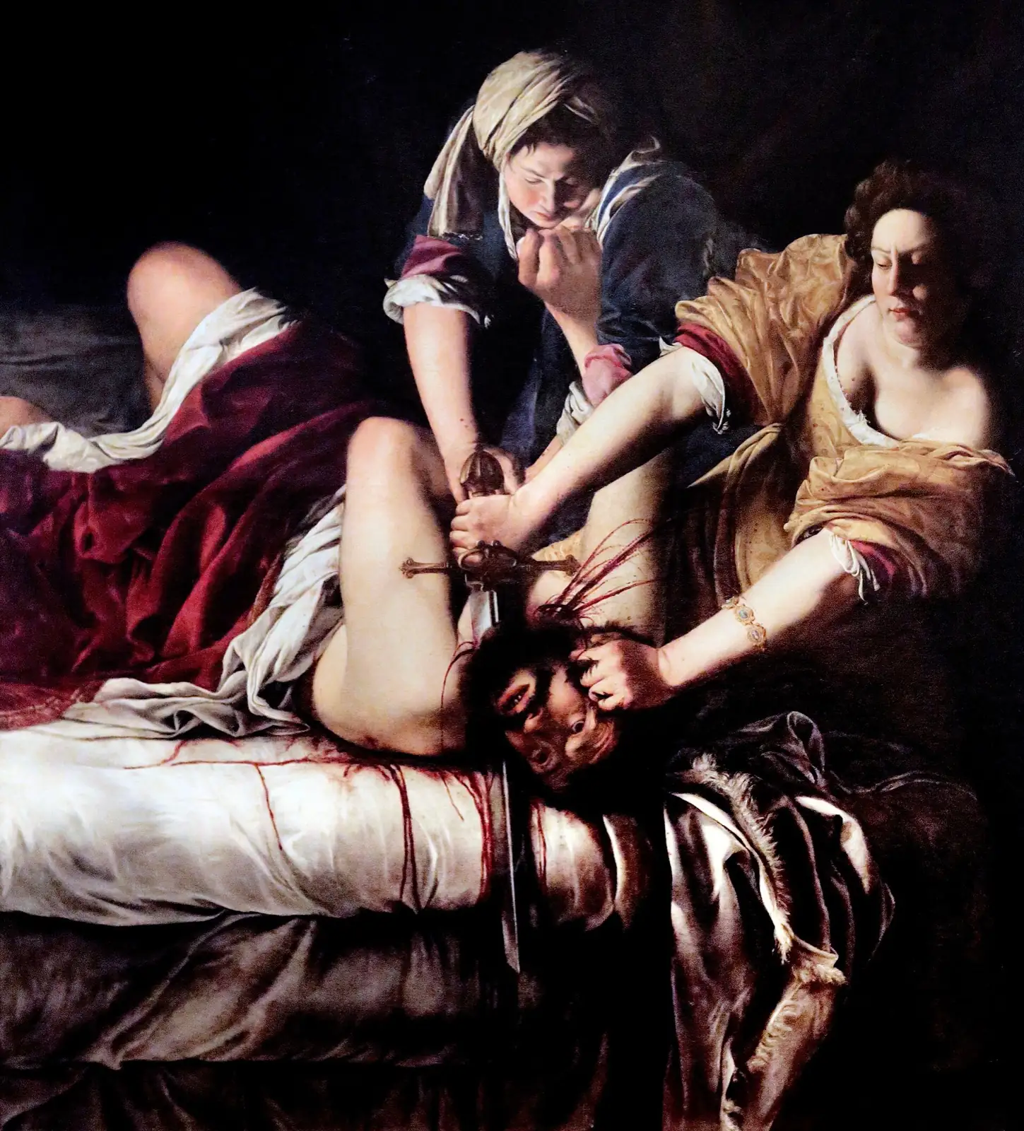 Two women hold down a man lying on a bed; one of them, in a golden dress, grips a sword