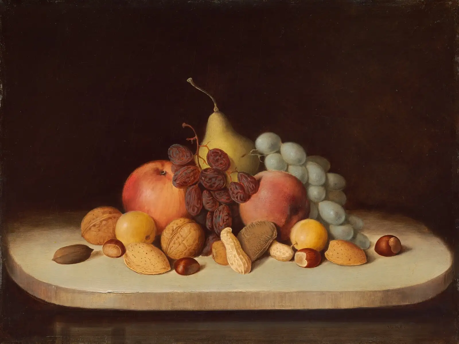 Pear, apples, grapes, raisins and assorted nuts on a white slab against an almost black background