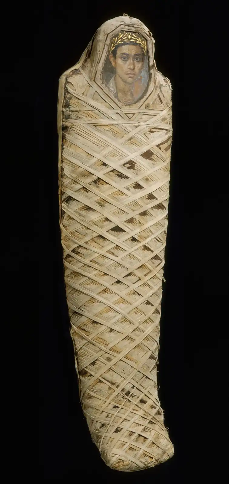 Mummy in linen bands crossed in diamonds, with a portrait of a young man in a gold wreath over the face