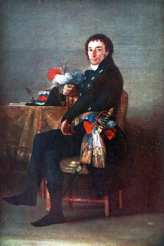 Man in a dark coat seated sideways on a chair beside a table holding a plumed hat and an inkwell