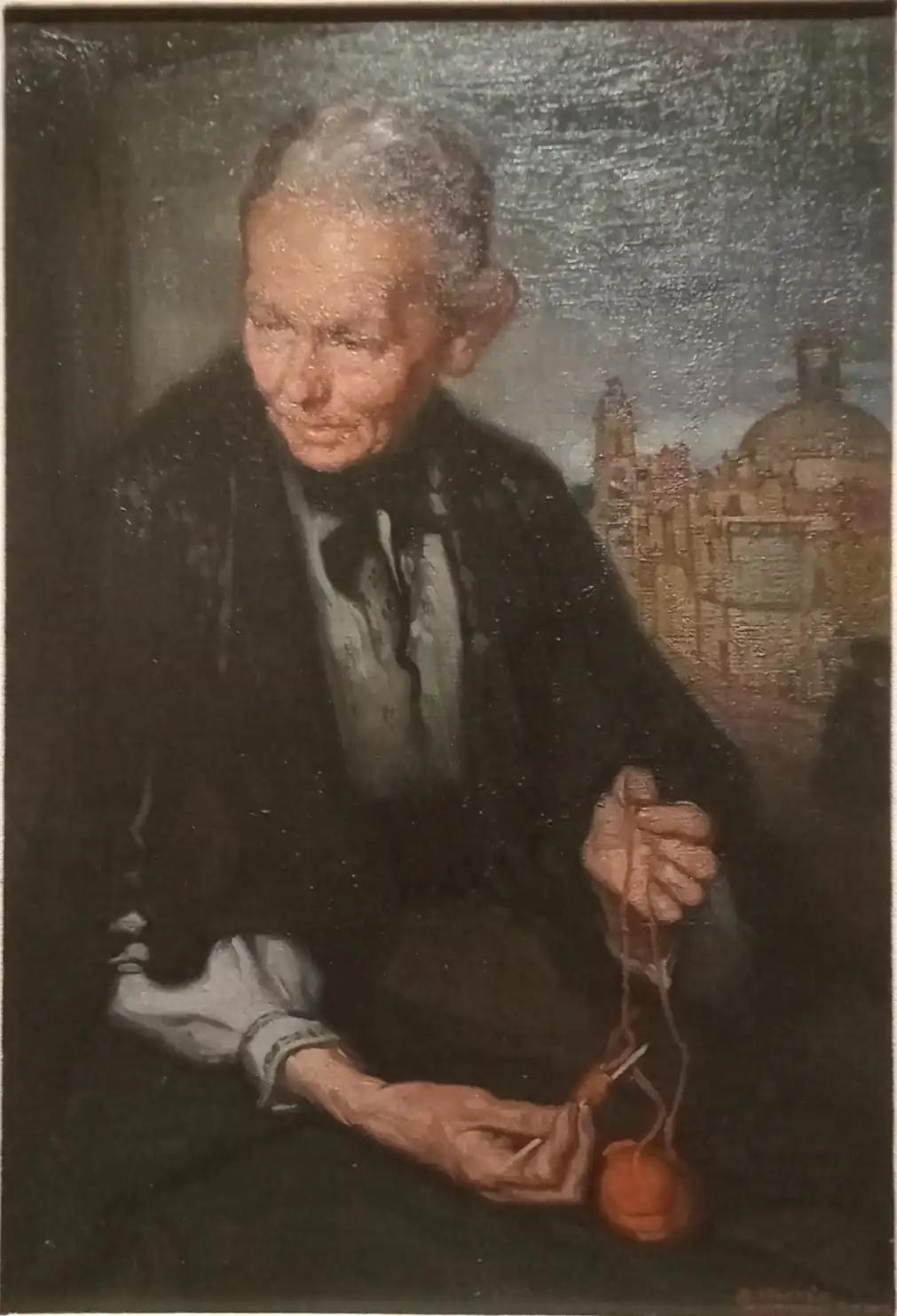 Anciana de cabello blanco y chal negro que enreda hilo de una bola anaranjada, con una iglesia de cúpula al fondo