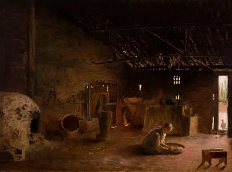 Interior oscuro de una cocina rústica con un horno de barro a la izquierda y una mujer que cierne granos en el piso