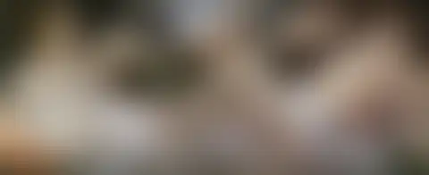 Mujer de vestido blanco recostada frente a un hombre dormido, mientras pequeños faunos juegan con una lanza y un casco