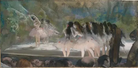 Stage with dancers in pinkish-white tutus, one with her arms raised, and dark heads in the foreground