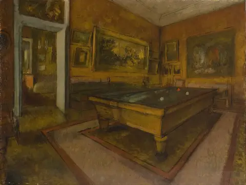 Empty room with a billiard table set at an angle, ochre walls covered in paintings and an open door on the left