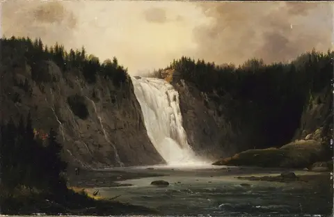 Cascada blanca que cae entre dos paredes de roca coronadas de pinos oscuros hacia una amplia poza de agua gris