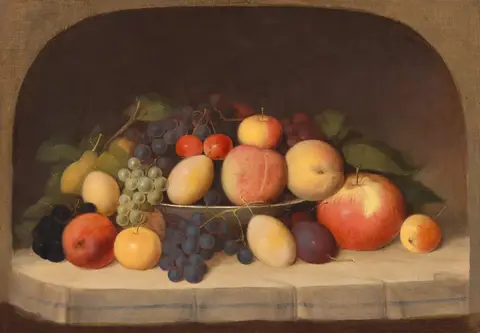 Frutas variadas amontonadas en un frutero y sobre una repisa con mantel, dentro de un nicho arqueado de fondo oscuro