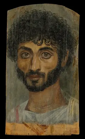 Thin-faced man with thick curly black hair, a full beard, large brown eyes and a white tunic against a gray ground