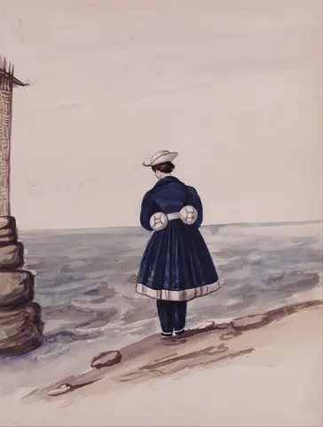 Mujer de espaldas con abrigo azul marino y sombrero blanco, de pie en la orilla frente a un mar gris