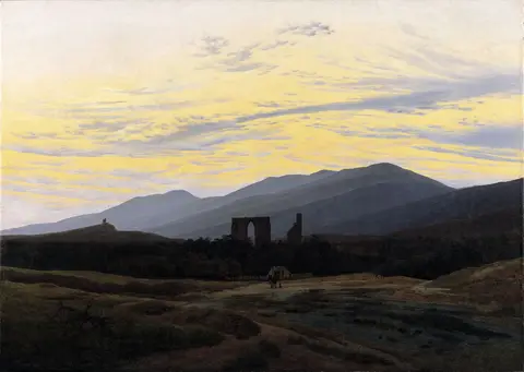 Ruined stone arch among dark trees below bluish mountains, under a yellow sky streaked with gray