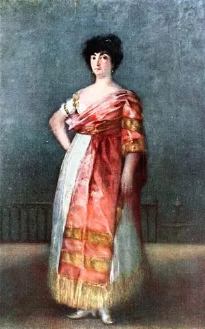 Woman standing with a hand on her hip, short dark hair and a pink shawl with gold bands over a white skirt