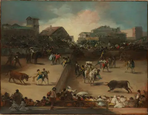 Bullring split in two by a wall, with two bulls, bullfighters, a mounted picador and spectators all around