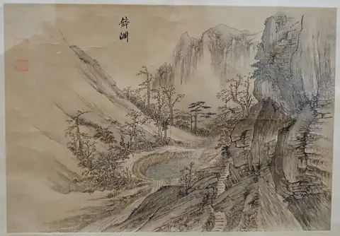 Round pool among cliffs fed by a small waterfall, with autumn trees and distant peaks fading into mist