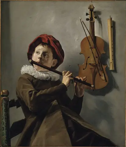 Niño con boina roja y cuello blanco toca una flauta travesera; en la pared cuelgan un violín y otra flauta
