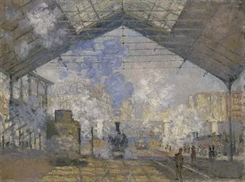 Interior de una estación de tren con techo de vidrio en forma de triángulo, una locomotora al centro y vapor azul