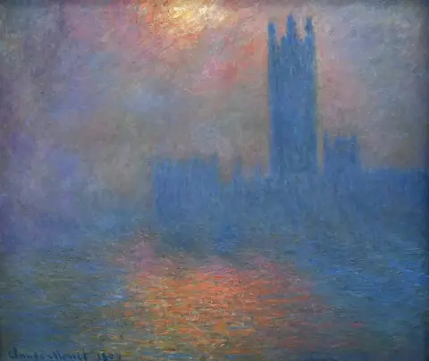 Silueta azul del Parlamento de Londres en la niebla, con un sol pálido arriba y reflejos anaranjados en el río