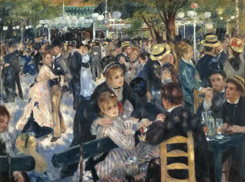 Multitud que baila y conversa al aire libre bajo los árboles, con lámparas de globo y una mesa en primer plano