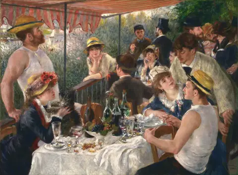 Grupo de amigos alrededor de una mesa con frutas y vino en un balcón con toldo rayado rojo y blanco junto a un río