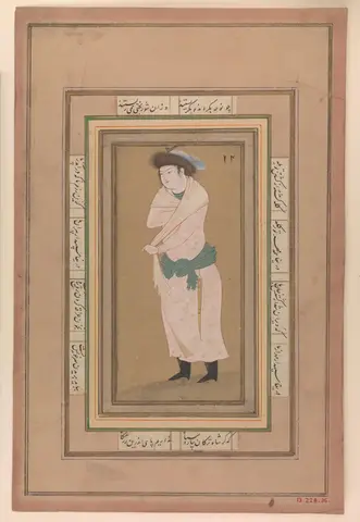 Young man standing in a fur hat, pale pink robe with gold motifs, light shawl, green sash and dagger, amid borders