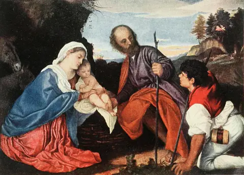 A woman in a blue mantle holds a baby before an old man with a staff and a kneeling young shepherd, beside a rock