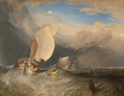 Barca de pesca con grandes velas claras y mucha gente a bordo, sacudida por olas bajo un cielo de tormenta
