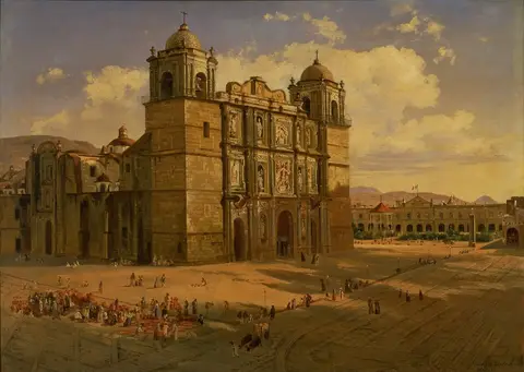 Fachada de piedra de una catedral con dos torres y cúpulas, vista en diagonal, frente a una plaza amplia con gente