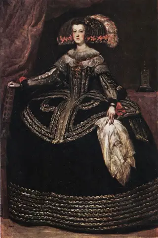 Woman in a huge black gown with silver braid and a wide plumed headdress, one hand resting on the back of a chair