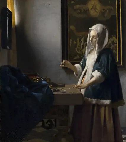 Mujer de chaqueta azul con piel blanca sostiene una pequeña balanza ante una mesa con perlas y oro, junto a una ventana