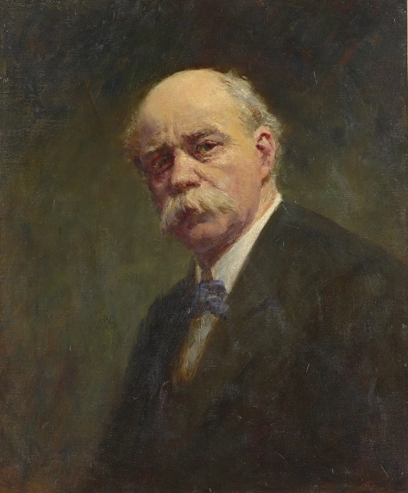 Hombre mayor calvo, de cabello y gran bigote blancos, con saco oscuro y moño azul, sobre un fondo verde oscuro