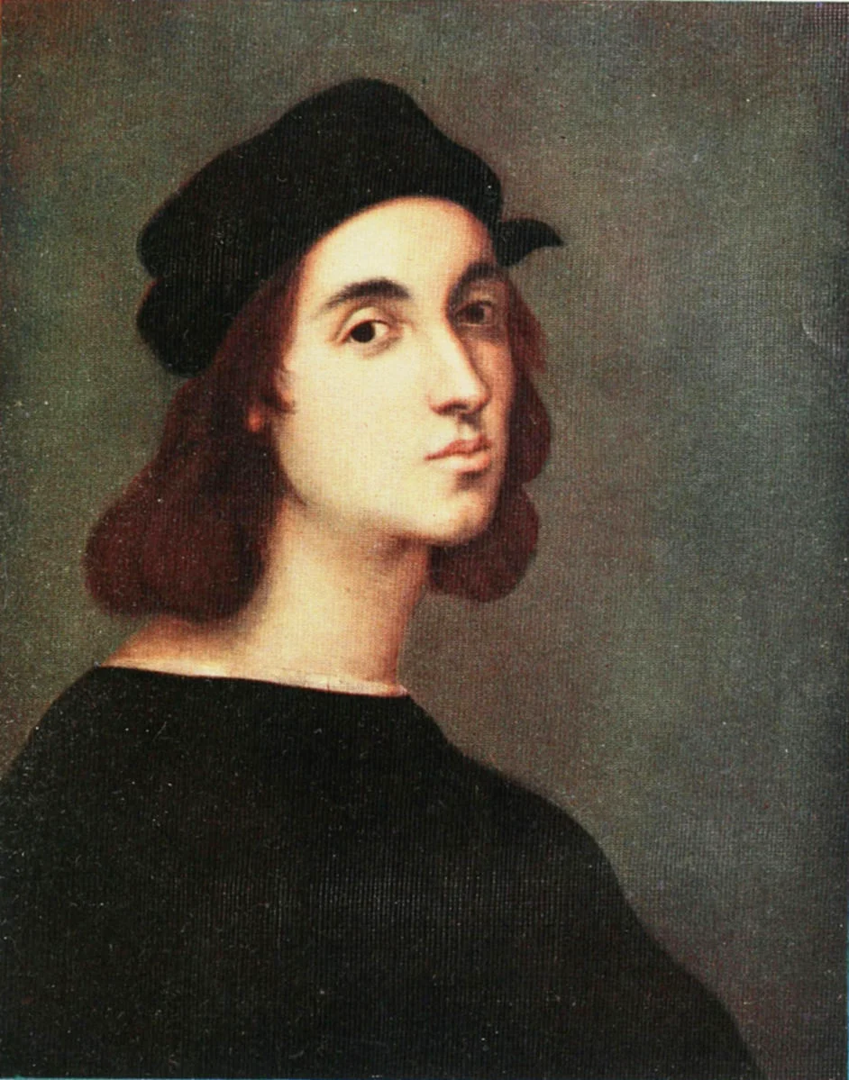 Young man in a black cap with shoulder-length brown hair looks over his shoulder against a gray-green background