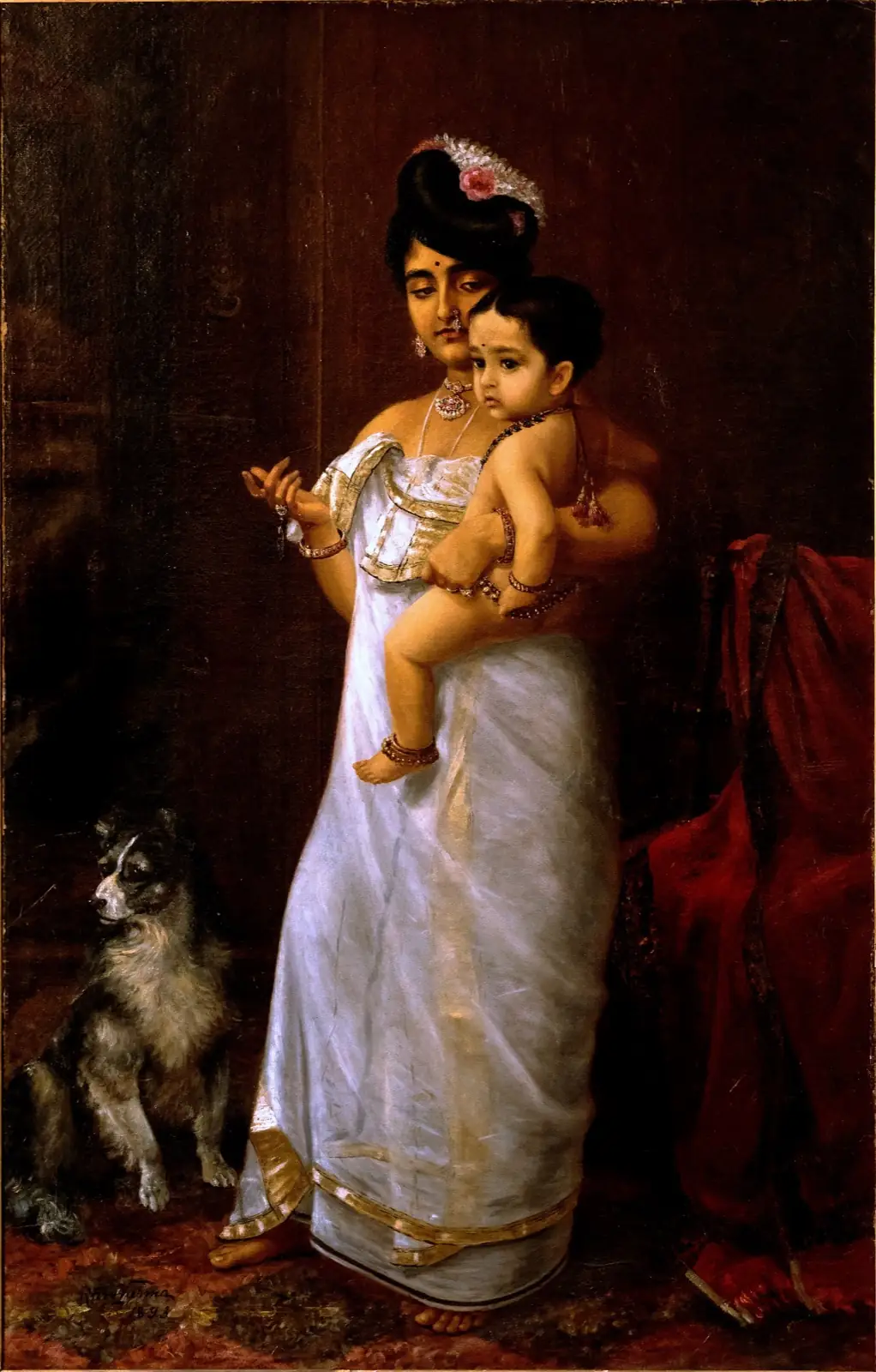 Woman in a gold-bordered white sari holding a small child on her hip, beside a seated dog and a red armchair