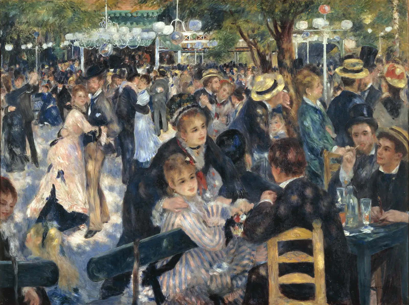 Crowd dancing and chatting outdoors under trees, with globe lamps overhead and a table in the foreground