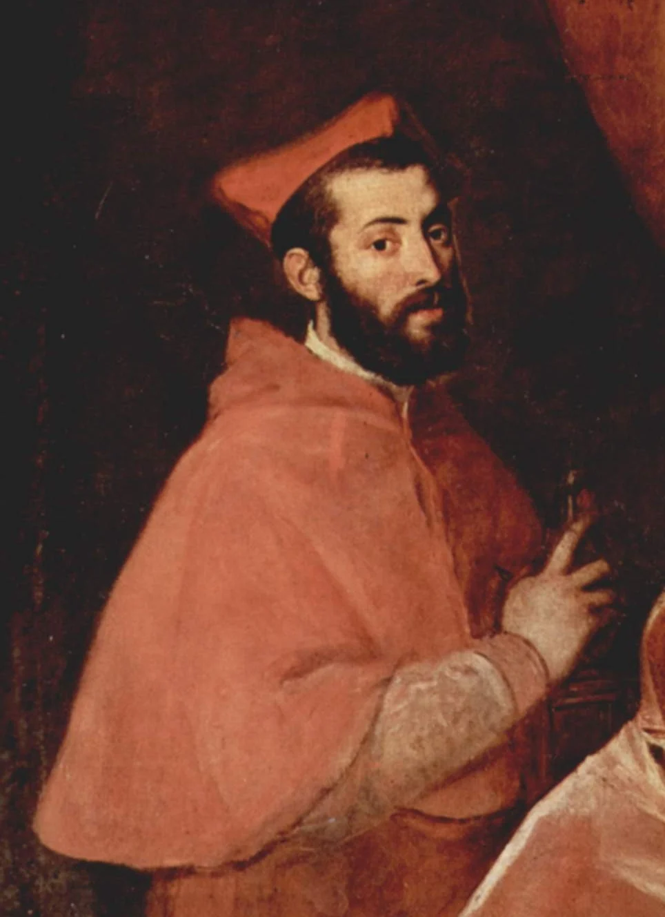 Dark-bearded man in a cardinal’s red biretta and cape, turned sideways and looking back at us